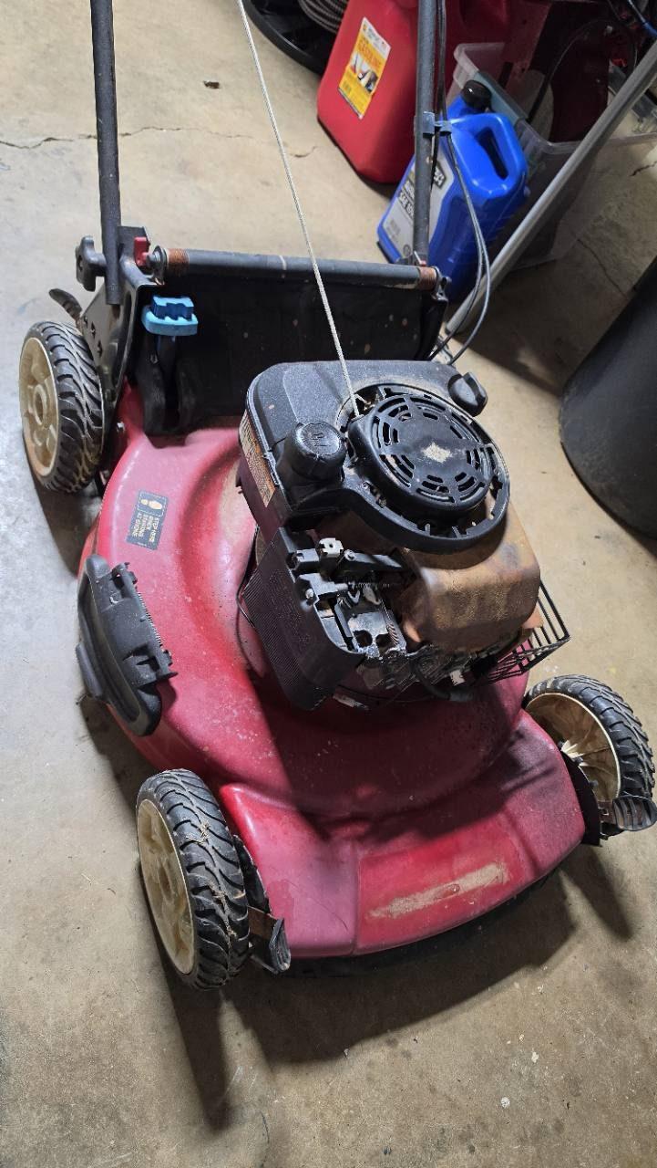 Push mower with engine components exposed during inspection